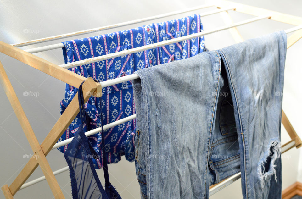 Shirt, jeans and bra hanging on a clothes rack to dry