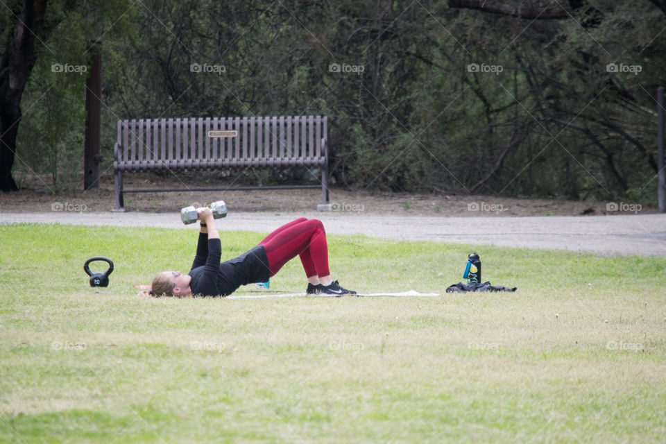 Lifting weights in a community park as gyms are closed