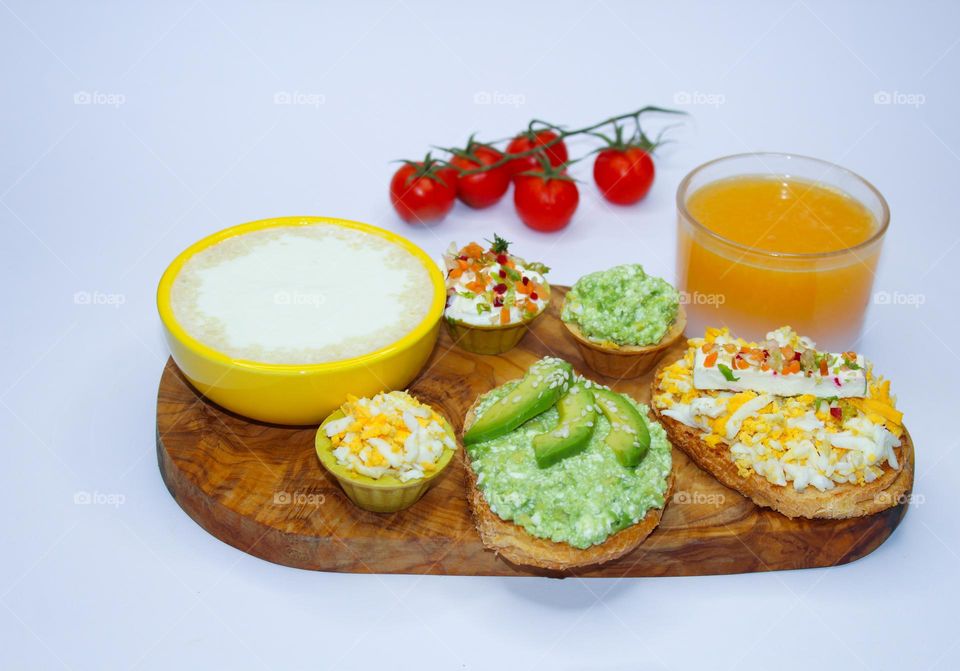 Vegetarian breakfast : bread with a spread of boiled eggs, avocado and cheese on the kitchen board