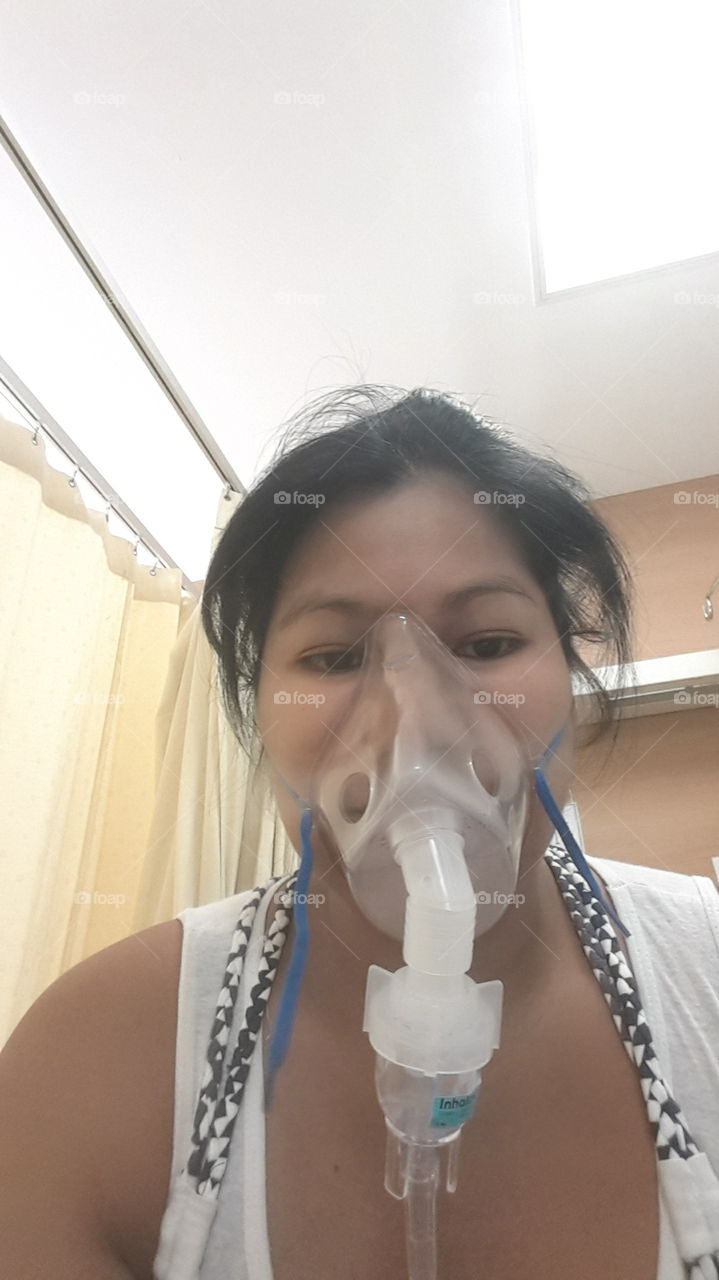 sick Asian woman wearing respiratory mask at hospital