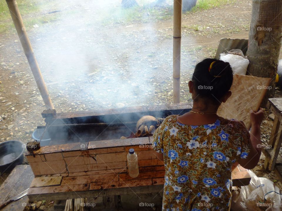 woman making smokes fish