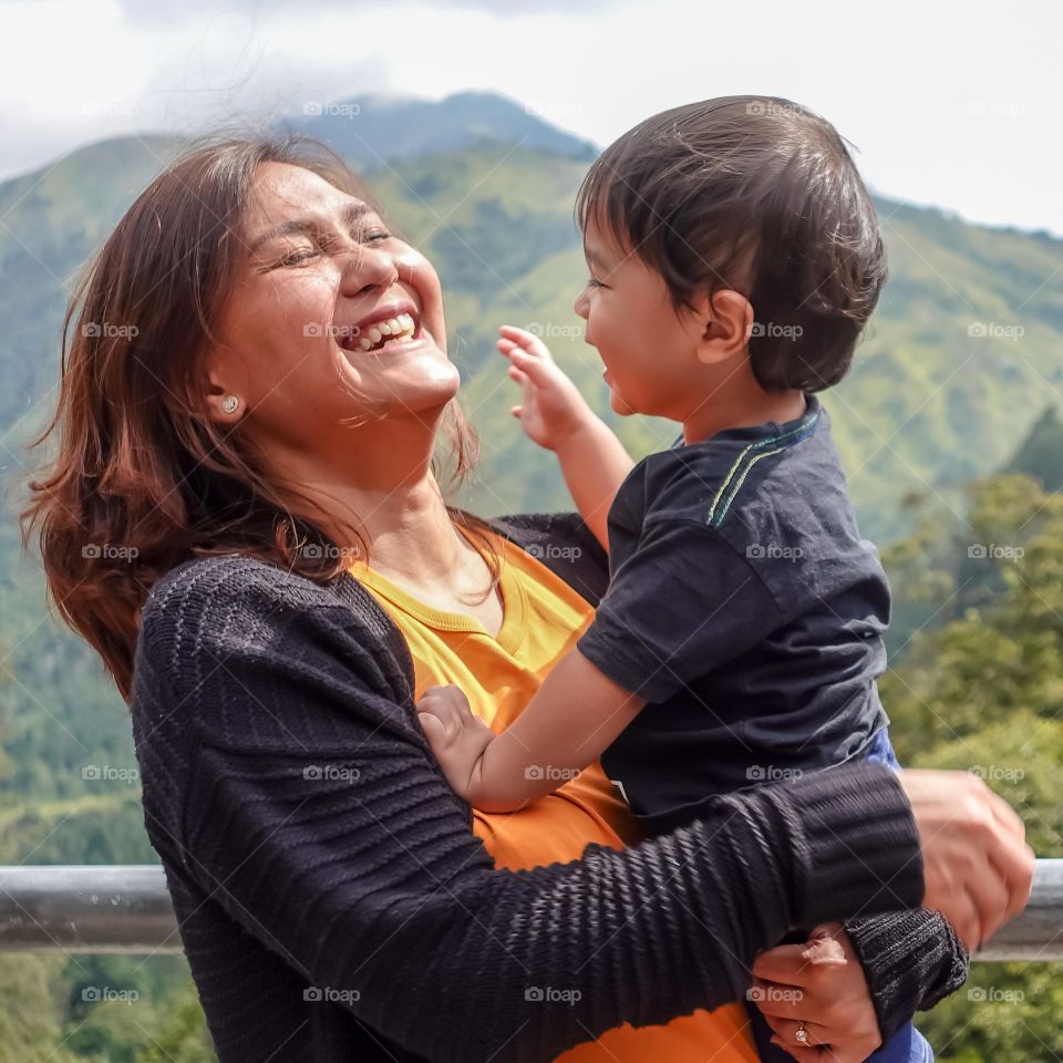 Mom and son laughing together in front of the mountain