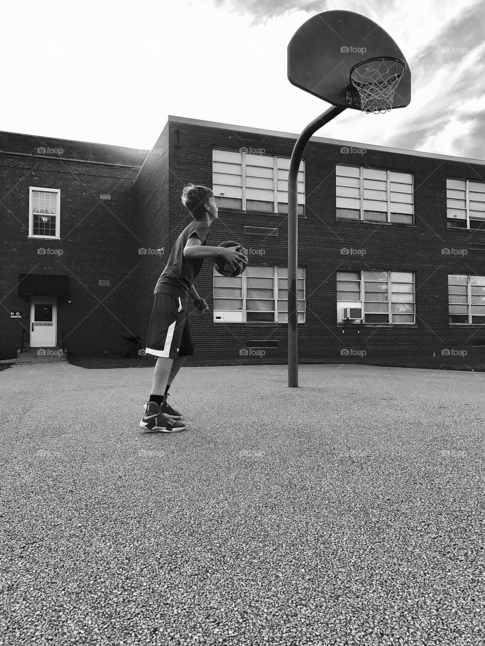Student playing basketball in schoolyard