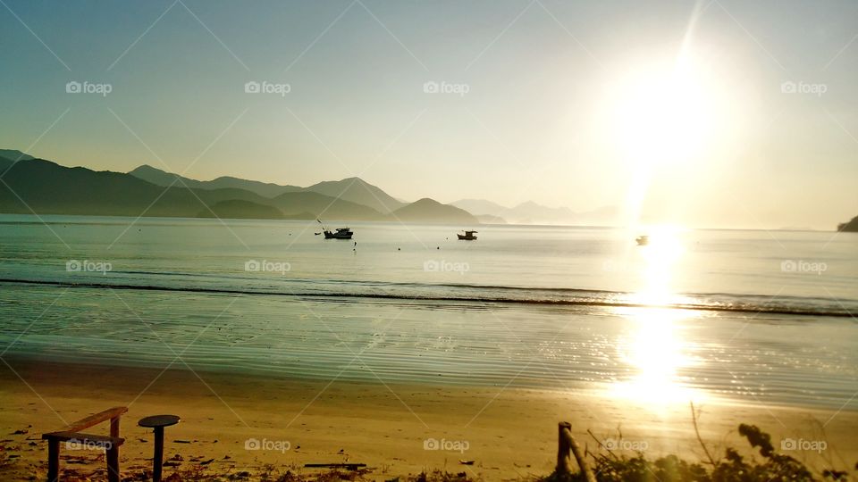 O pôr do sol na praia.