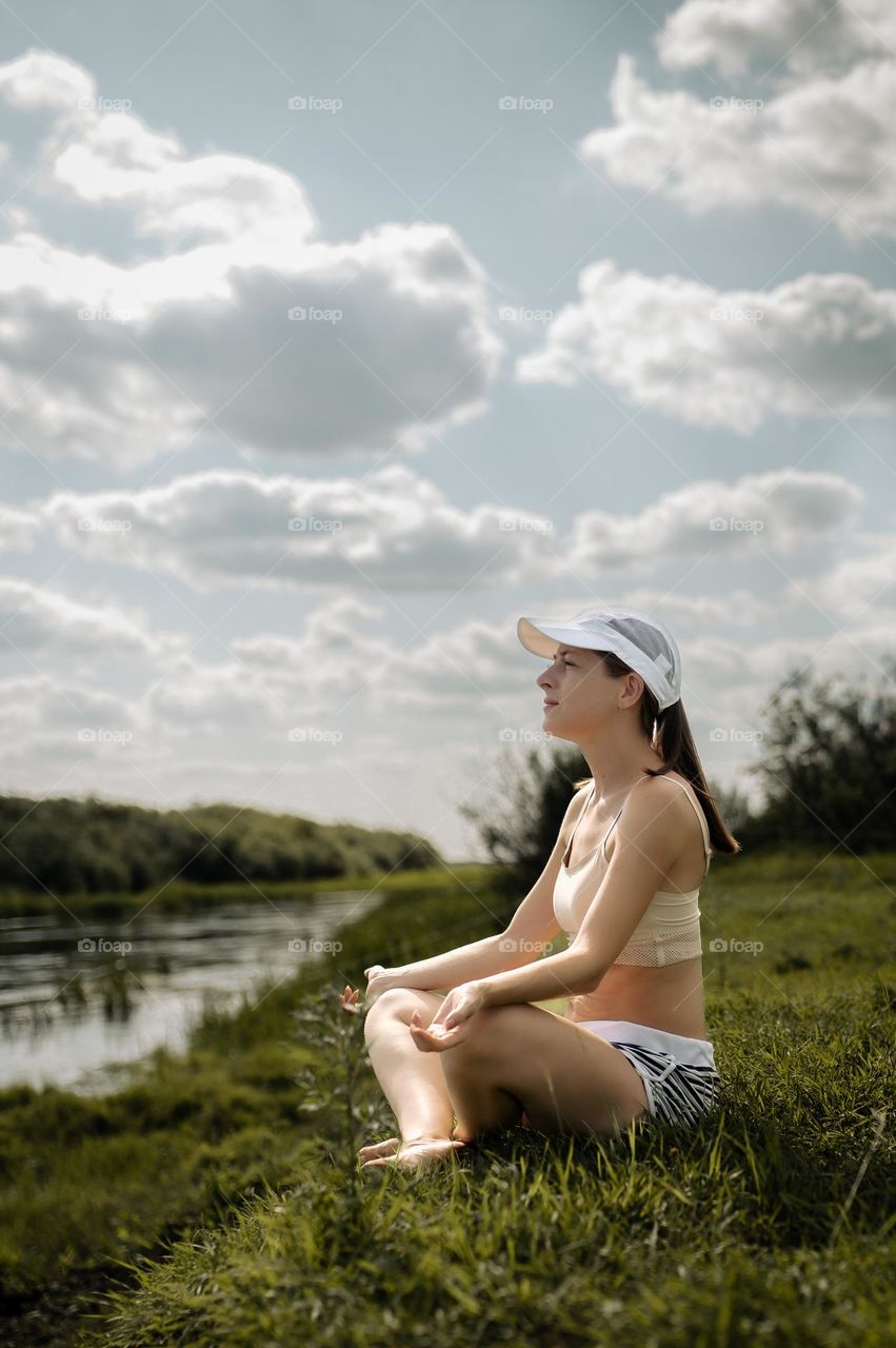 girl resting meditation on the river bank