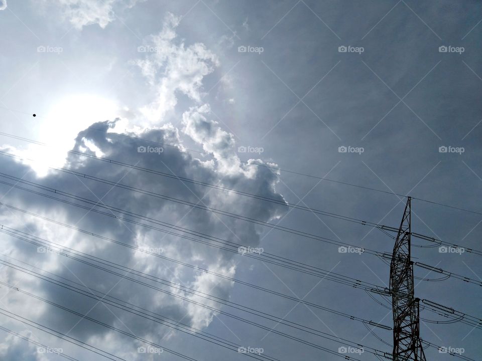 Electric cable with the sun and funny clouds.