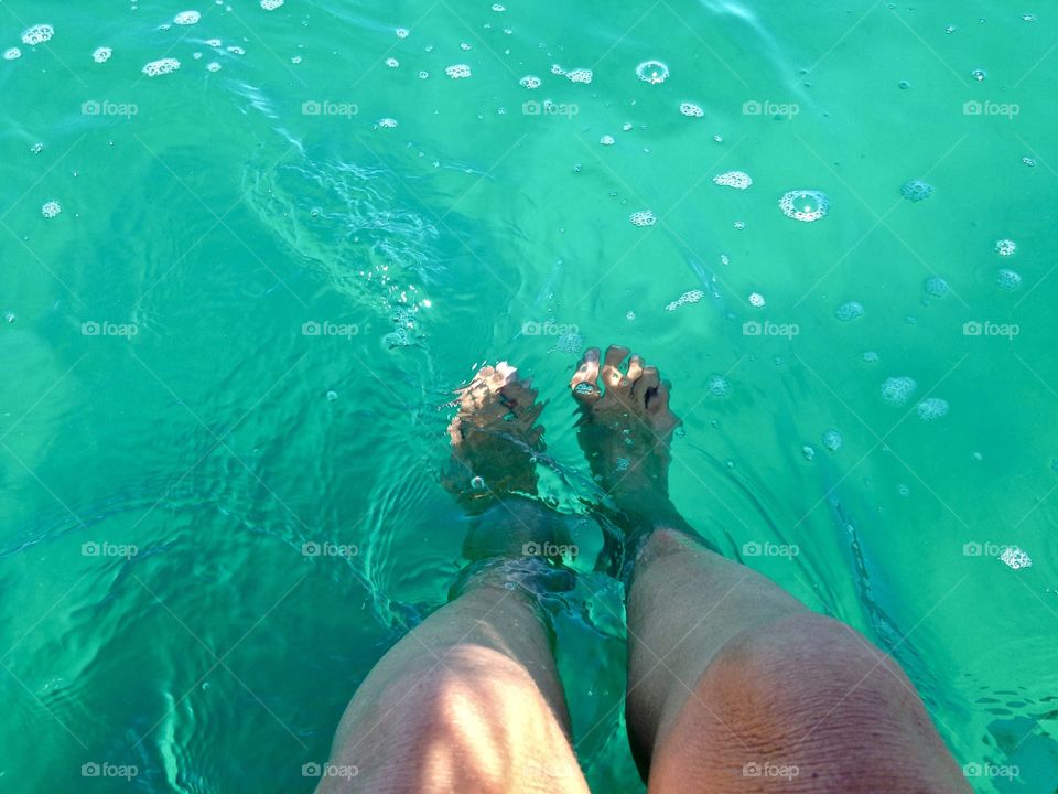 feet in transparent sea water in Spain