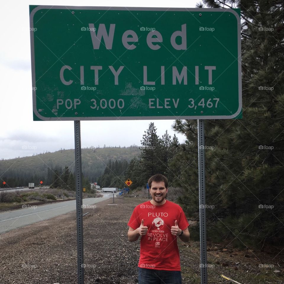 Standing in front of a Weed, California city limits sign 