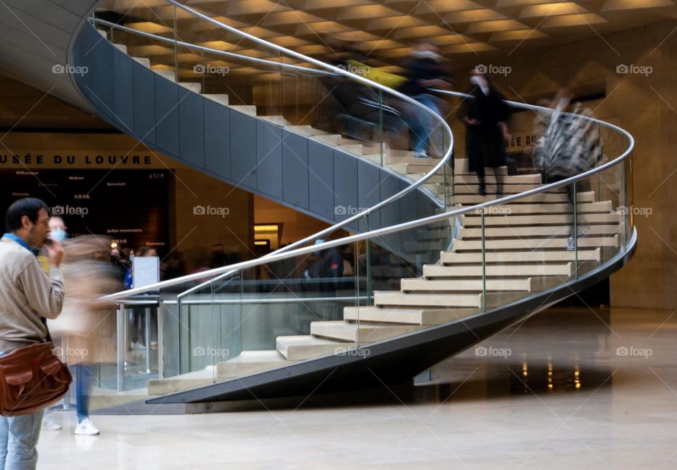 People walking down the stairs at the Louvre museum