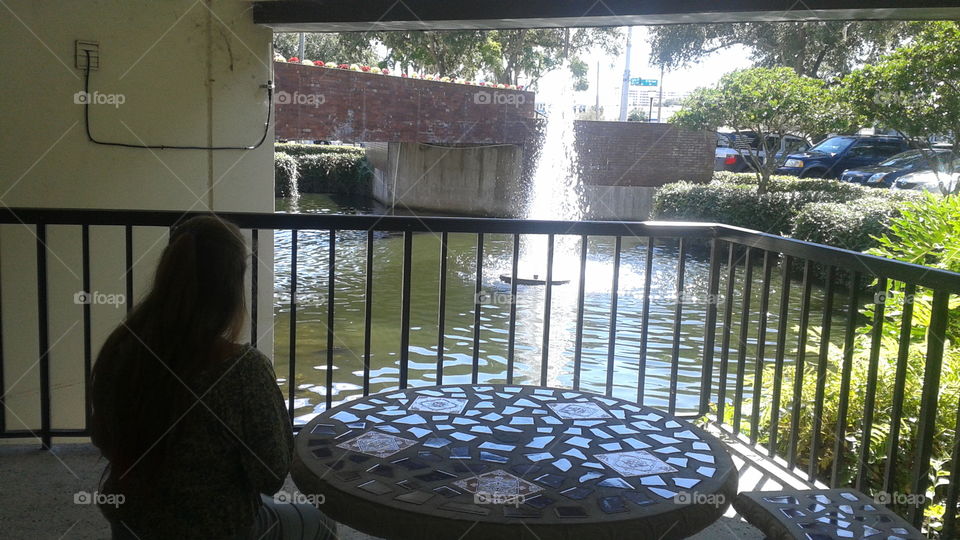 Enjoying the Beauty. My daughter enjoying the beauty of this fountain and pond outside of an office building.