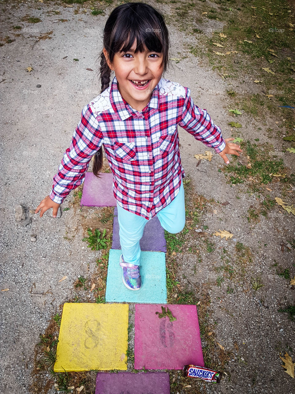 Little girl is playing hopscotch