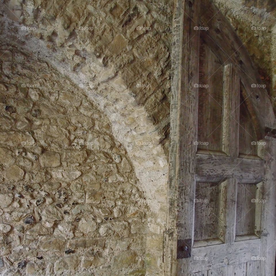 A worn wooden door in a corridor attached to an old stone building in Dover England. 