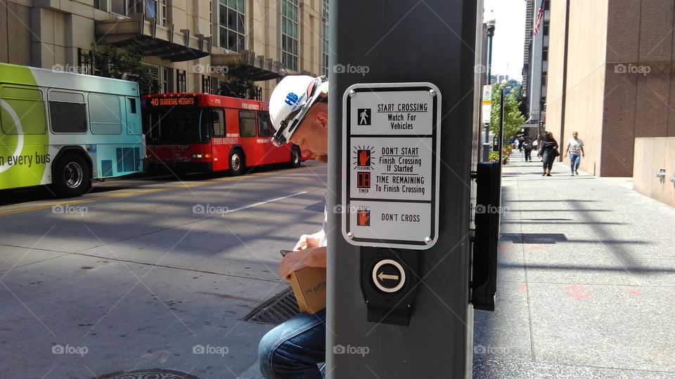 cross button, pedestrian walk way button, worker, building, city bus, city street's