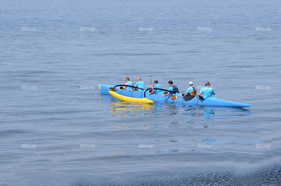 Kayakers paddle as  a team in a kayaking competition in the Puget sound of West Seattle, Washington.