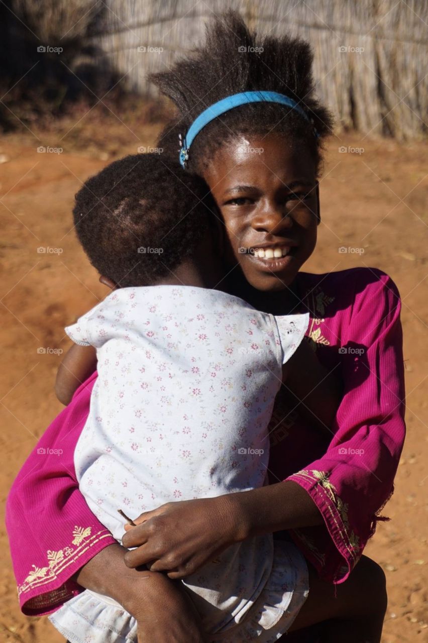 Girl carrying her little sister