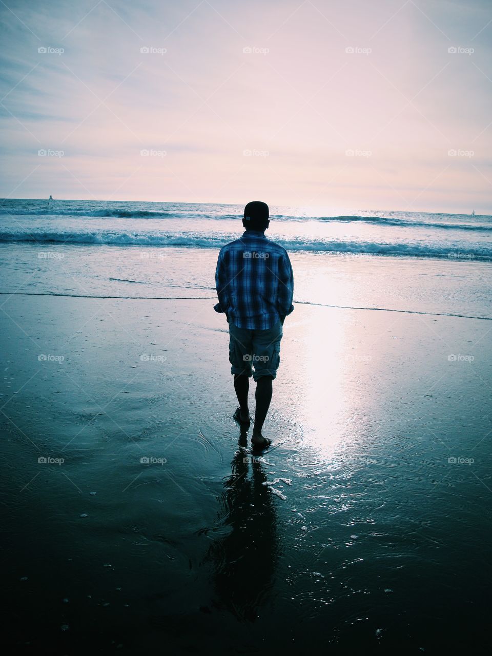 Rear view of man standing on sandy beach