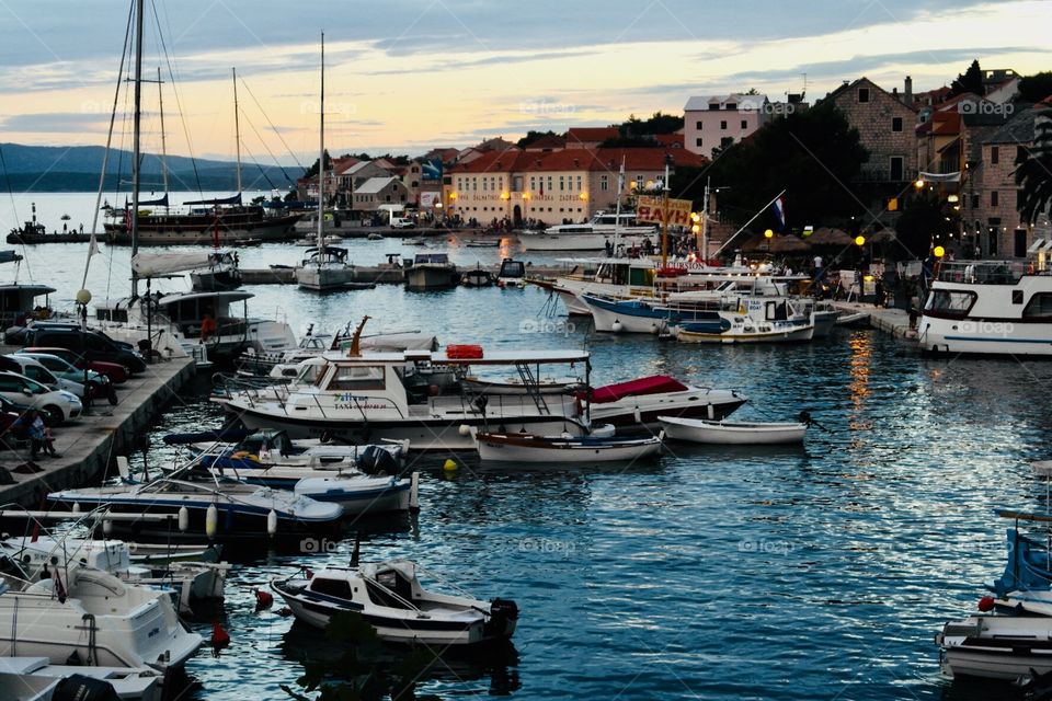 A Croatian village and its harbour with boats in Sunset