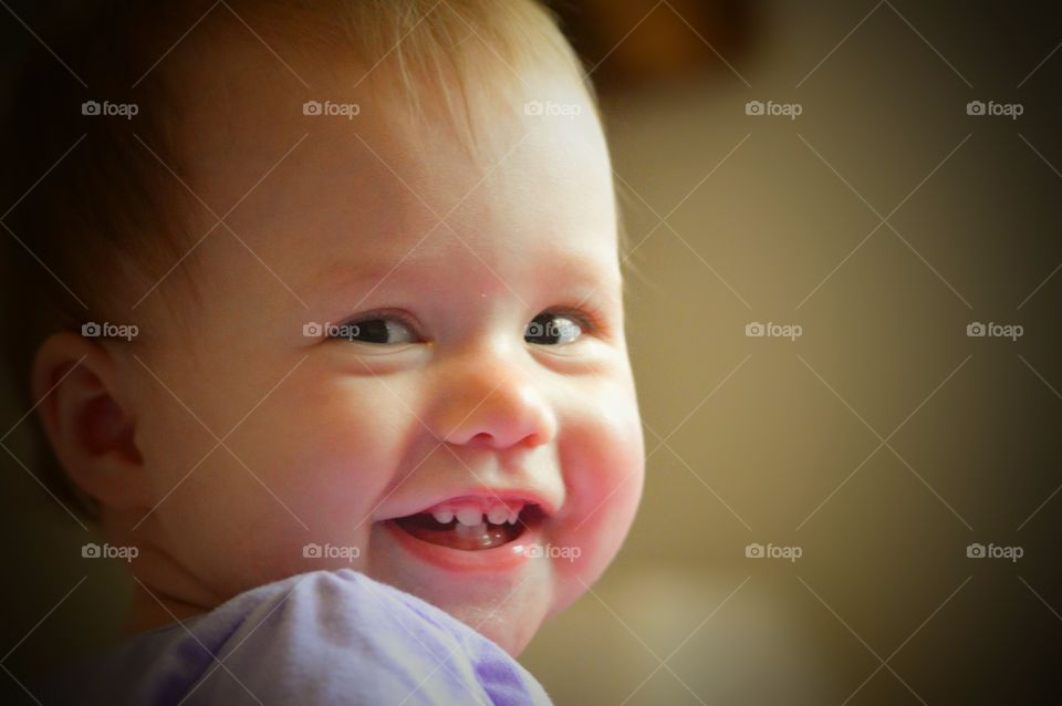 A happy, giggling baby with a toothy grin.