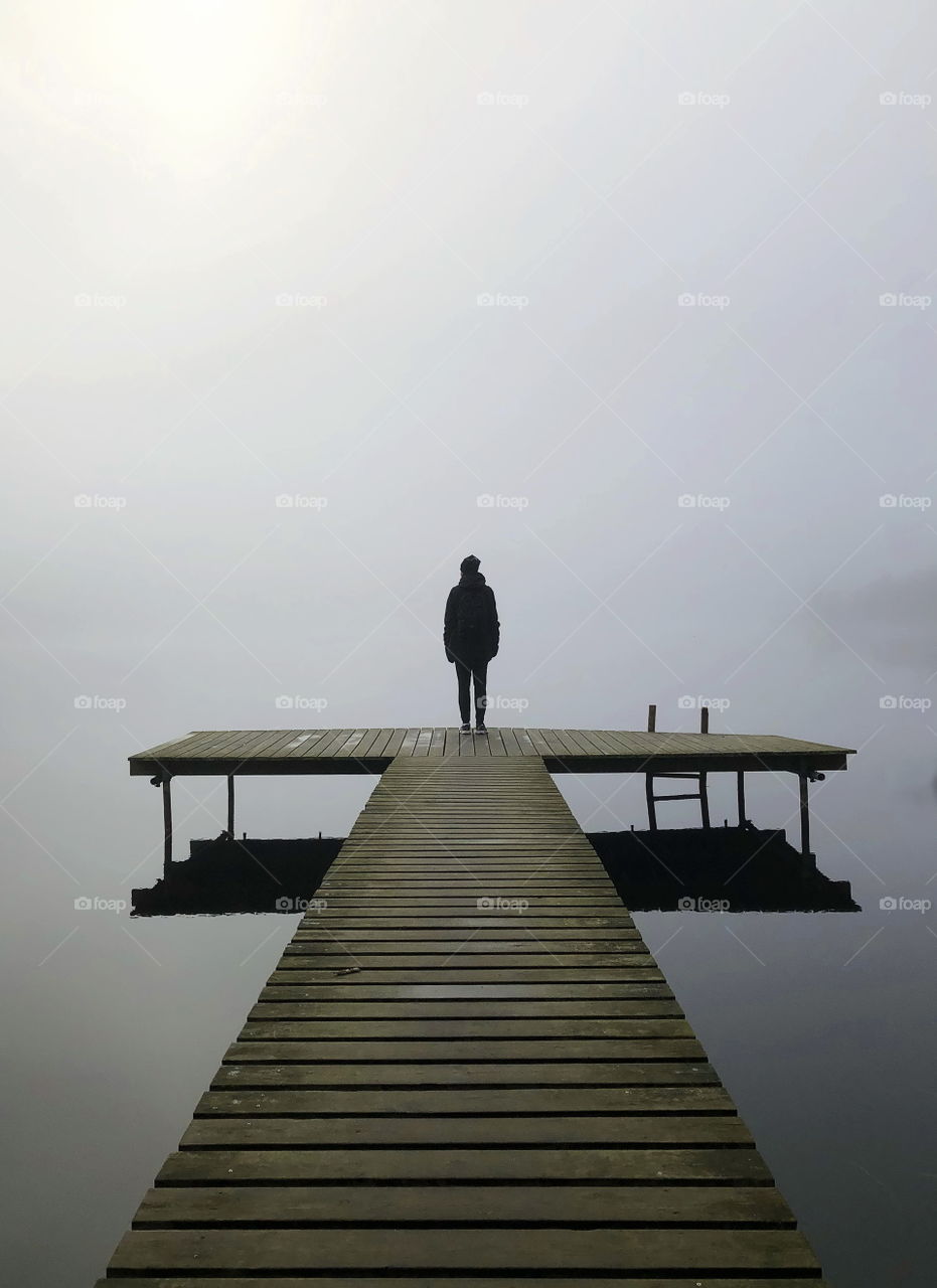 Standing alone in the fog, by the lake