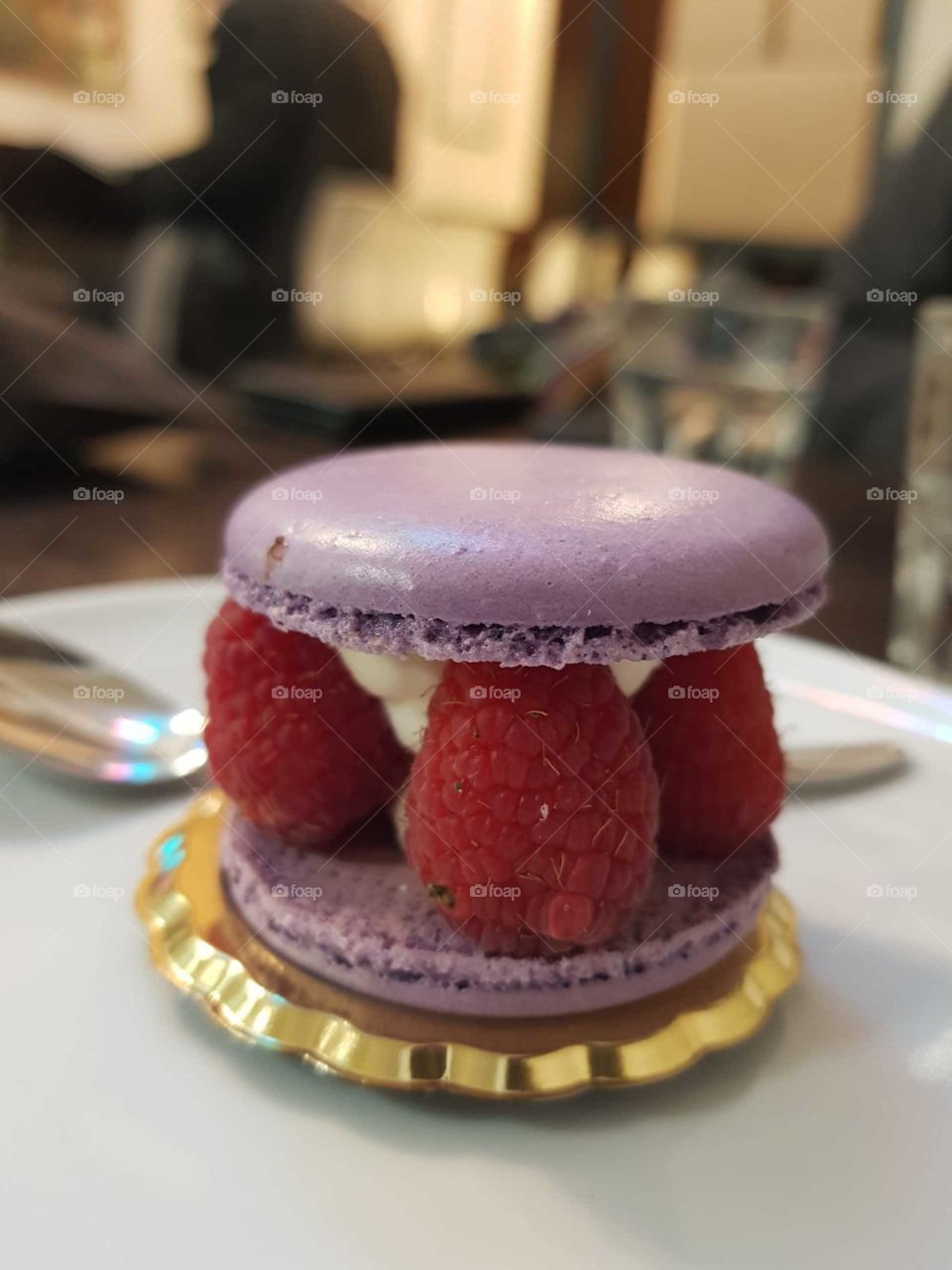 Sandwich macaron filled with chantilly cream and raspberries at the bar