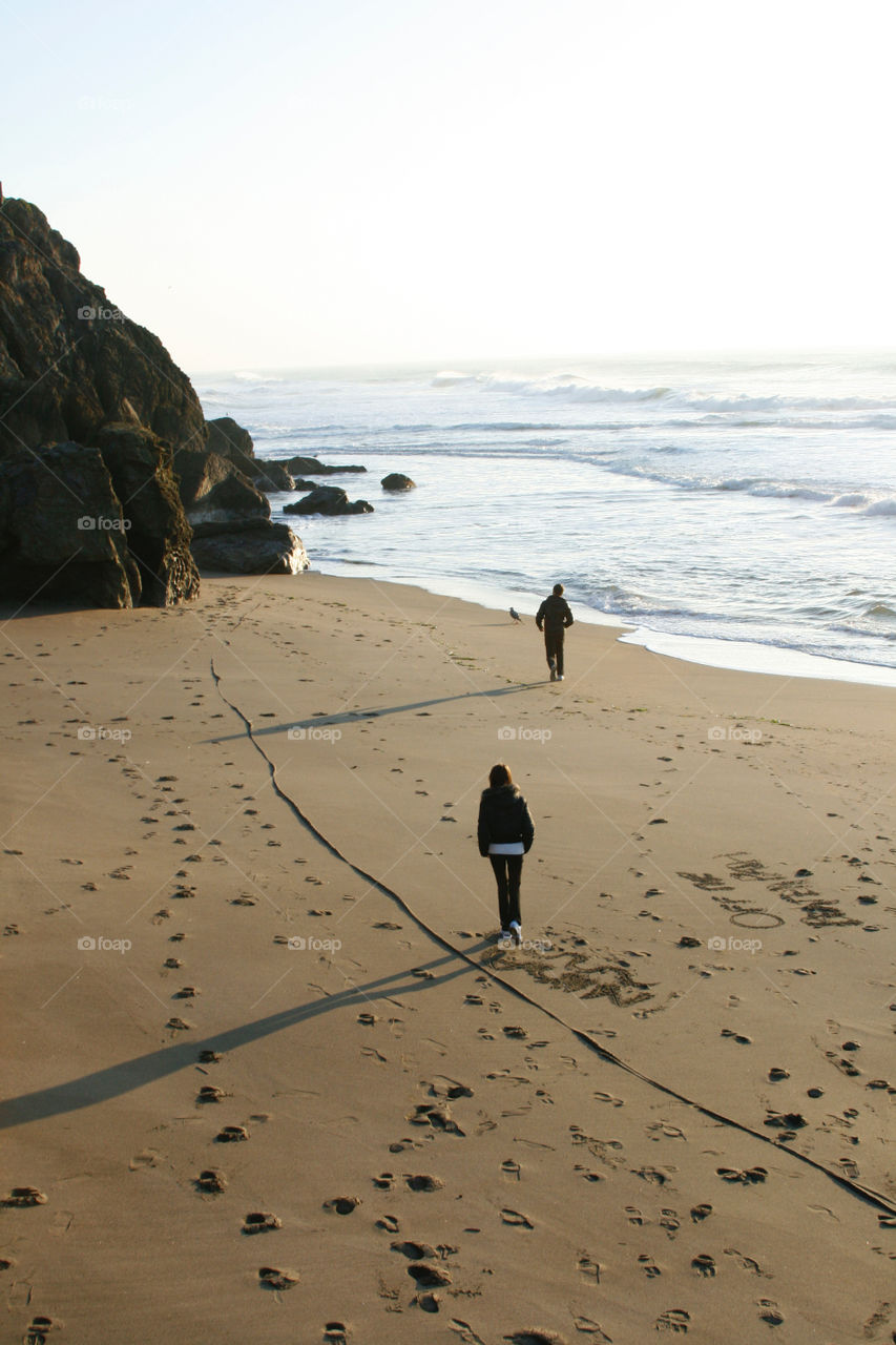 Two people walking at the beach 