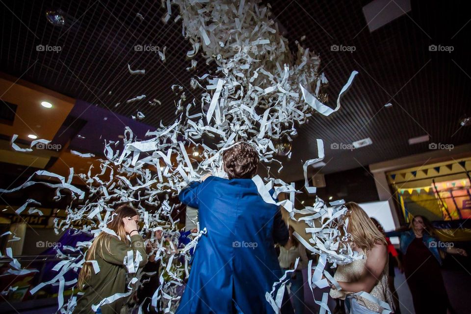 photo of the moment when white confetti was sprinkled on the dancers during dancing at the disco