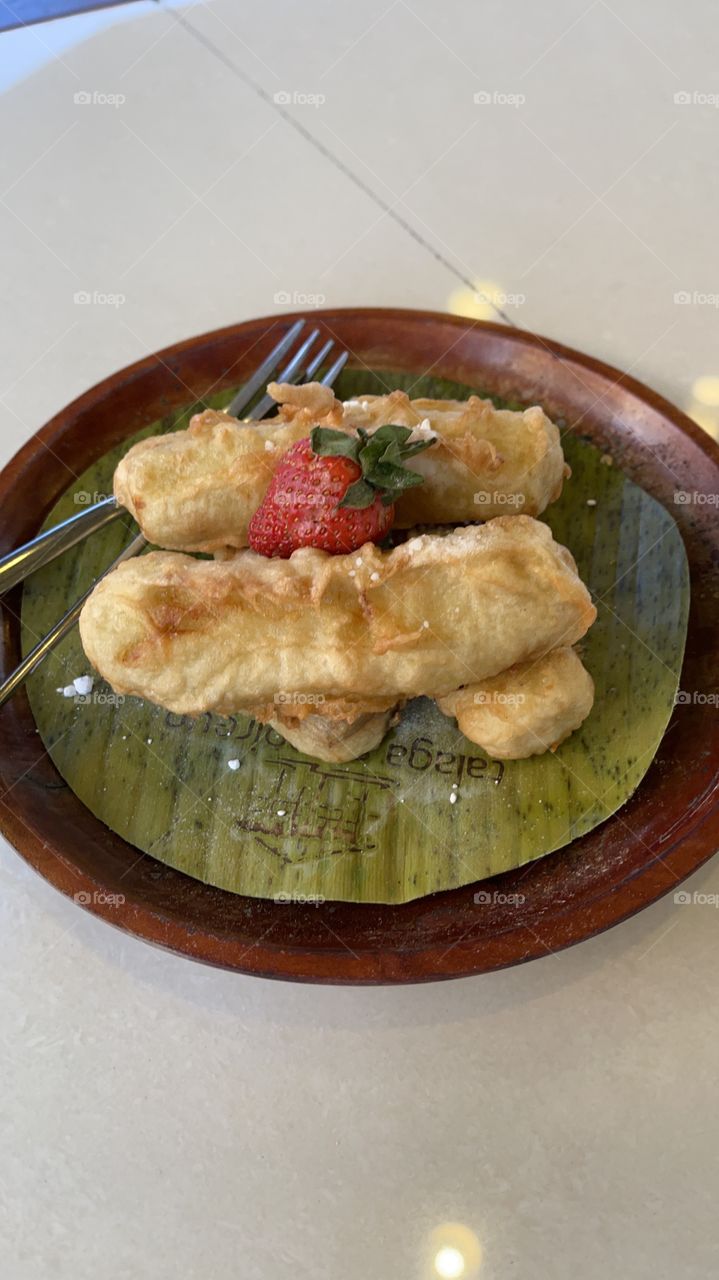 Banana fries with strawberry and sugar,put in banana leaf,ready to eat with fork