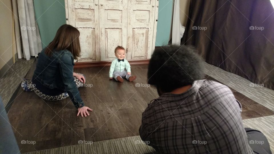 Baby boy getting his picture taken in a portrait studio by a professional photographer