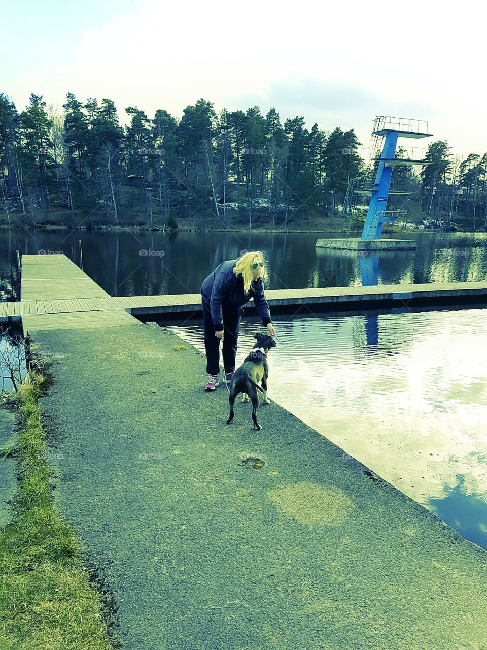 girl play with dog near lake water