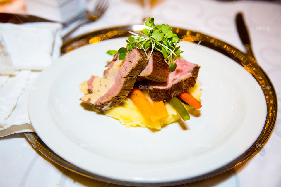 Delicious fillet steak with sauce on fresh vegetables and mash.