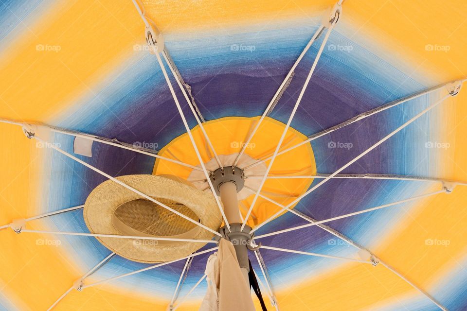 Straw hat and umbrella on the beach