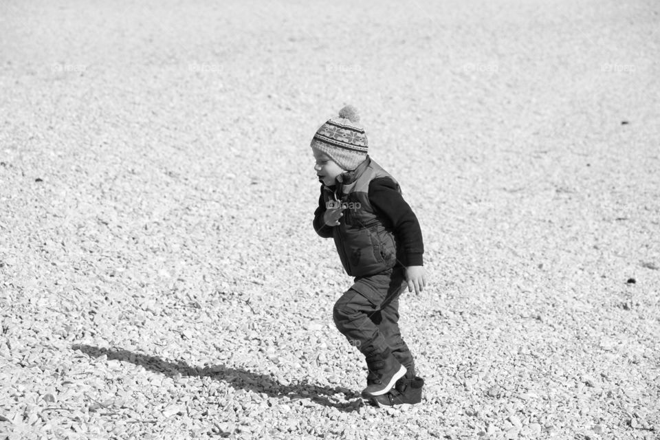 Playful boy on the pebbles