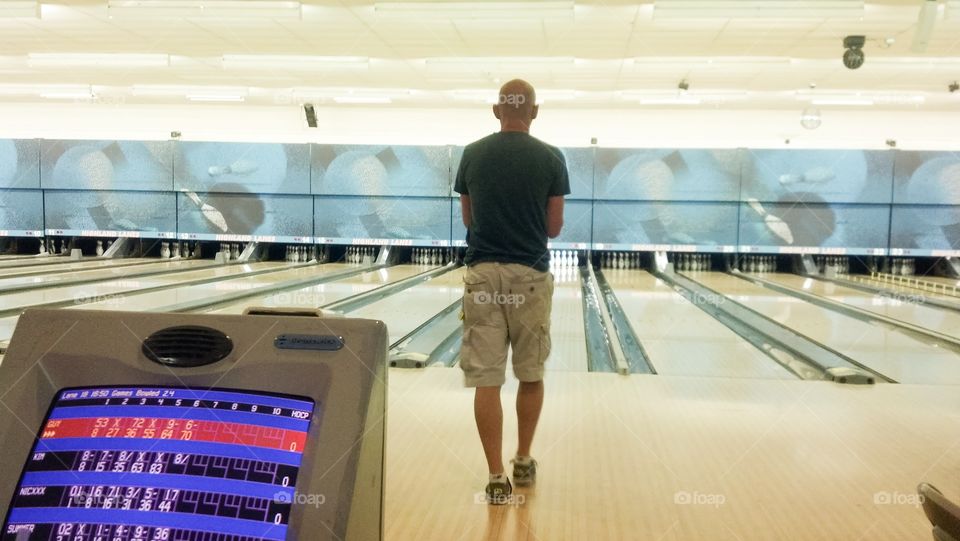 Rear view of man preparing to bowl