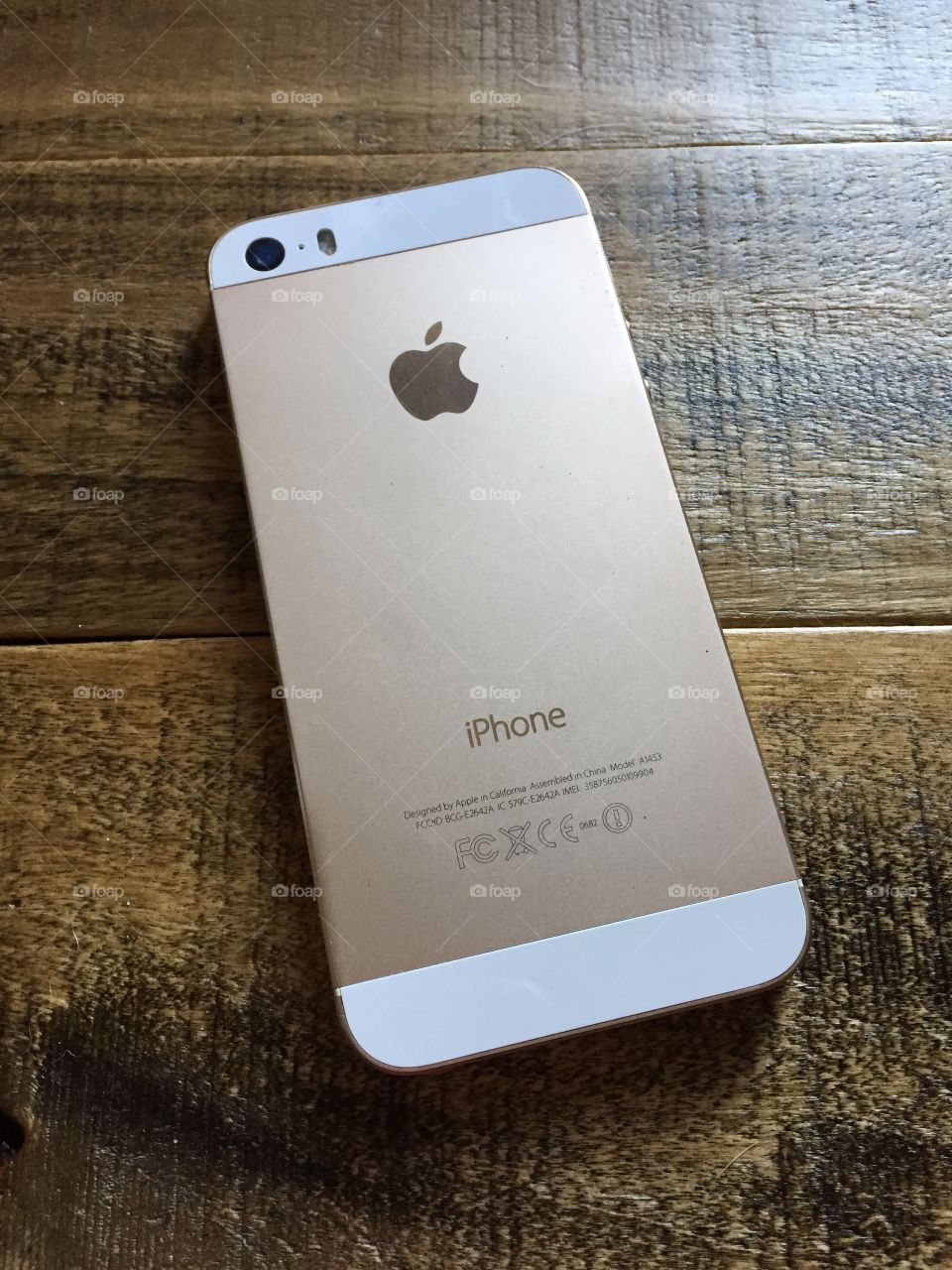 Gold iPhone 5s - 32GB. Photo of a gold iPhone 5s, 32GB on a reclaimed wood table