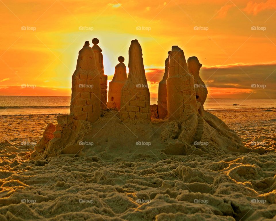 Sunrise and sunsets of the USA - A sandcastle stands tall on the sandy beach in front of the Gulf of Mexico and a magnificent sunset 