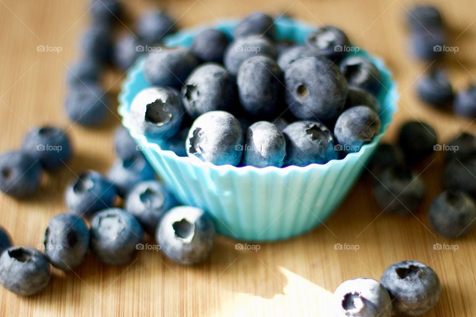 Fruits! - Blueberries In blue silicone baking cups on bamboo surface