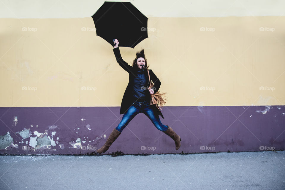 Woman jumping with an umbrella