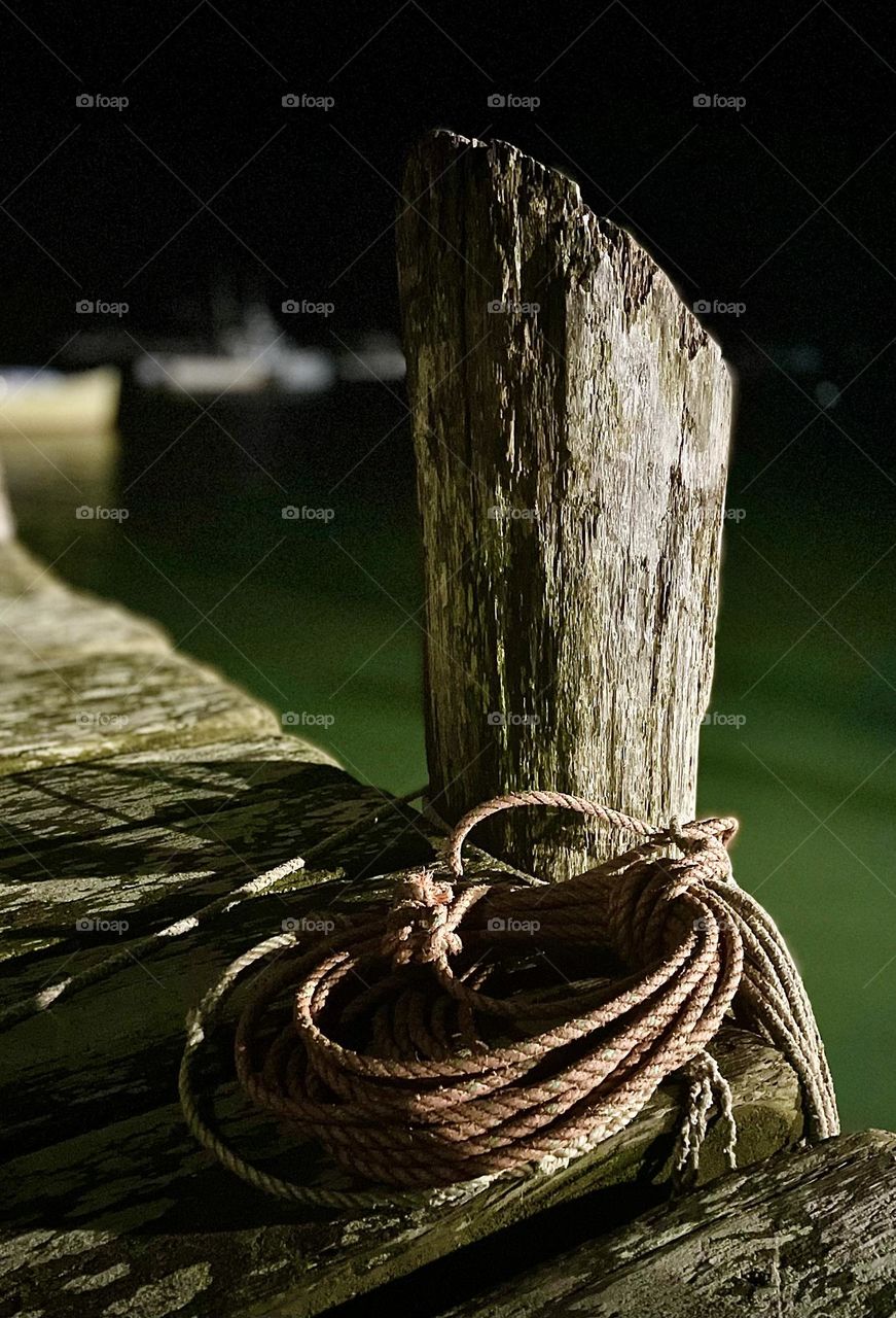 “Night Watch.” Coiled rope rests next to a wooden piling on a cold winter’s eve.