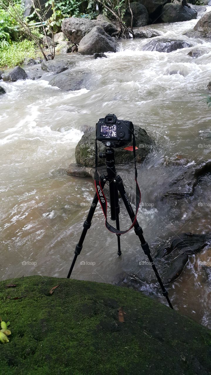 canon 6d camera set up on a tripod for a long exposure shot of a river in rainforest in Thailand