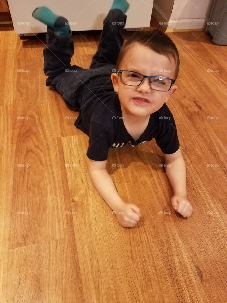 Little boy lying on floor with spectacles