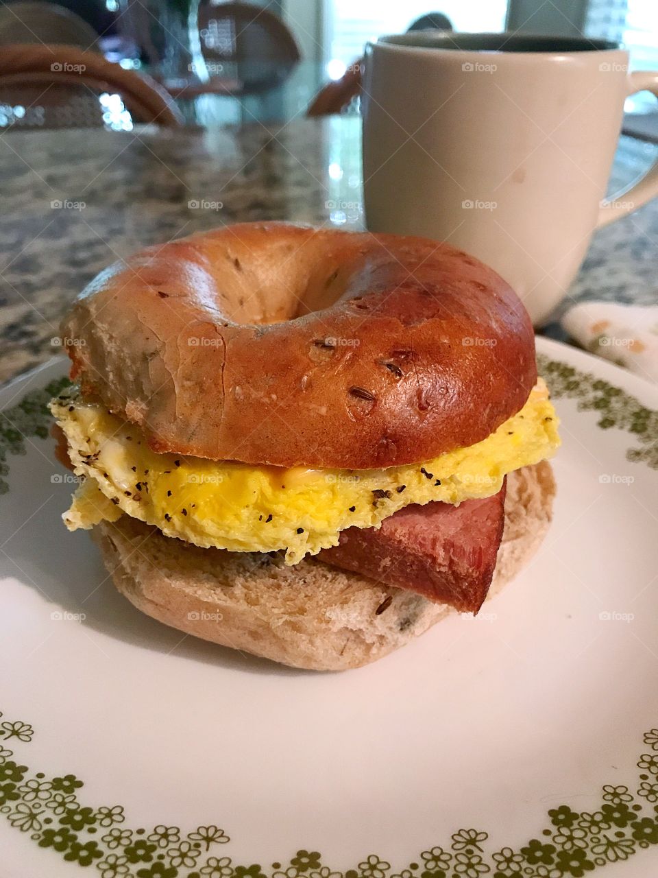 Country ham and egg with cheese on a toasted rye bagel. 