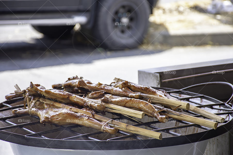 Grilled chicken in bamboo on the grill of the stove.