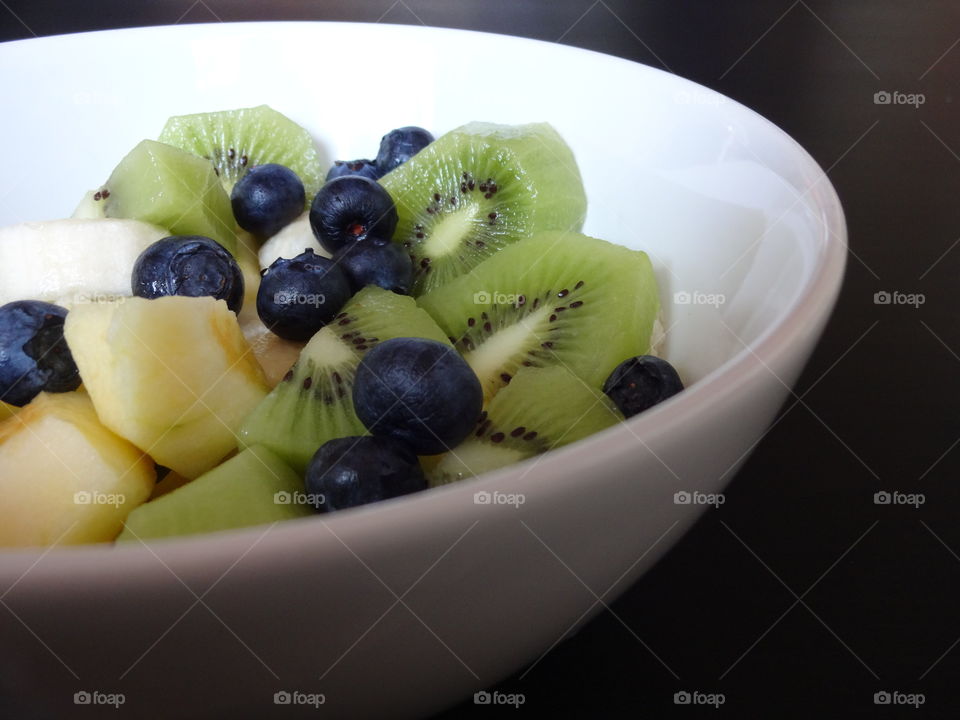 Healthy fruits breakfast full of vitamins with apple, kiwi, banana and berries