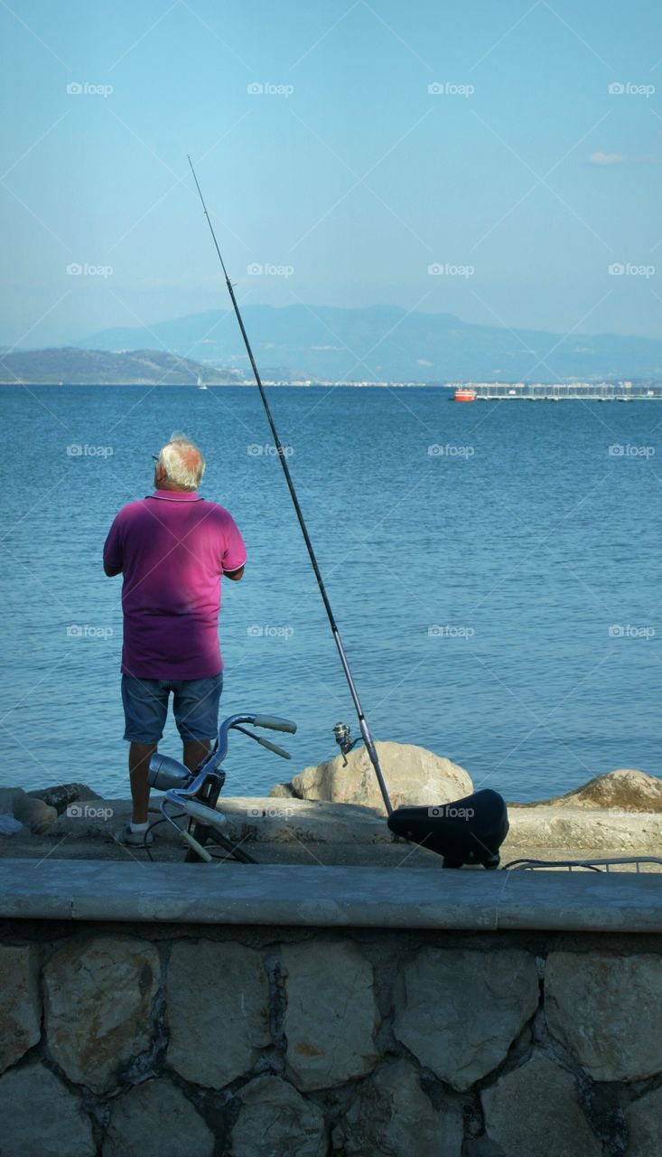 Old man enjoying a sunny day on the coast