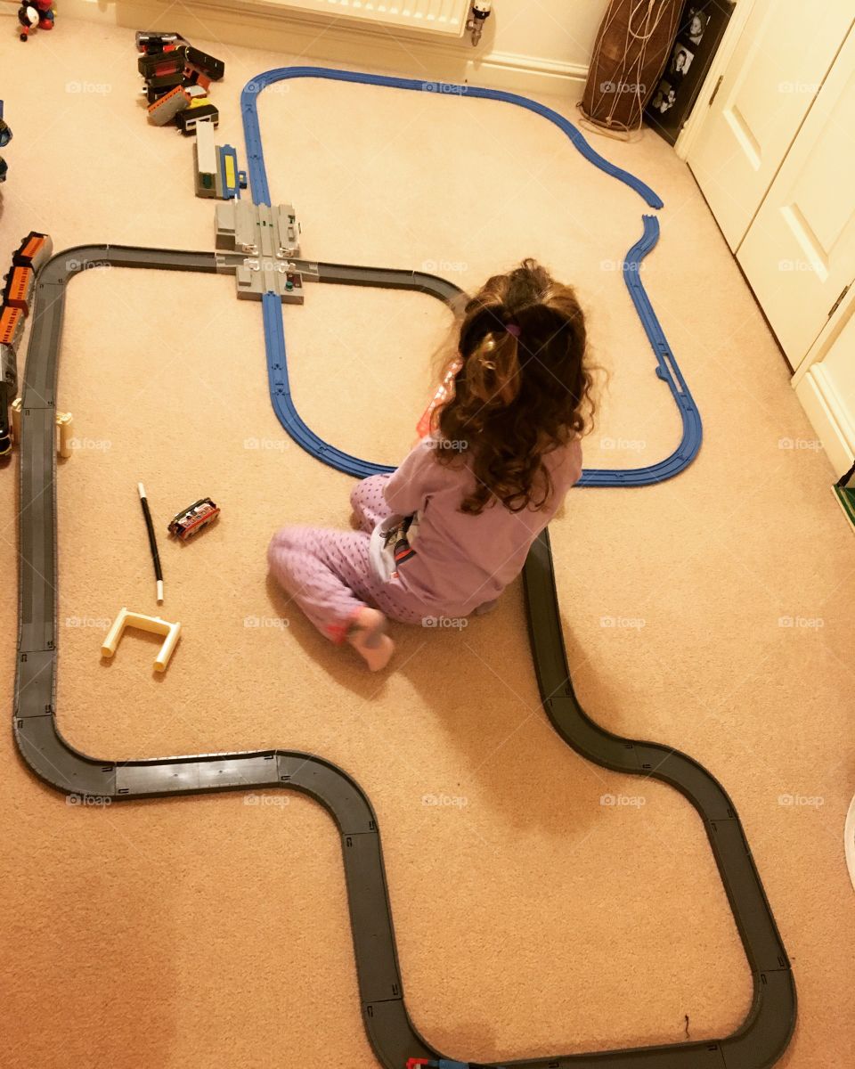 Kid in bedroom playing with train set