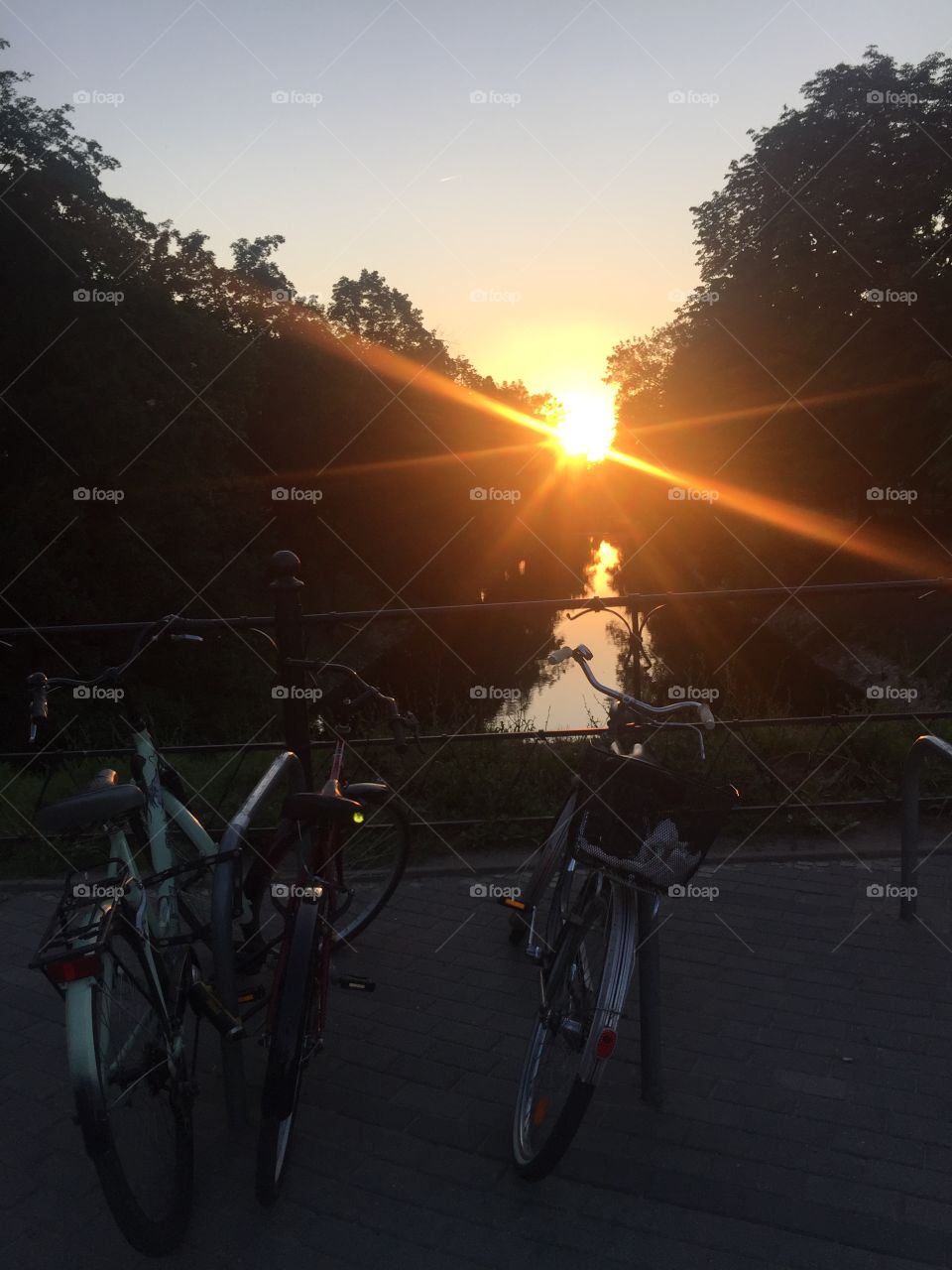 Parked in the riverbank bicycles at the sunset