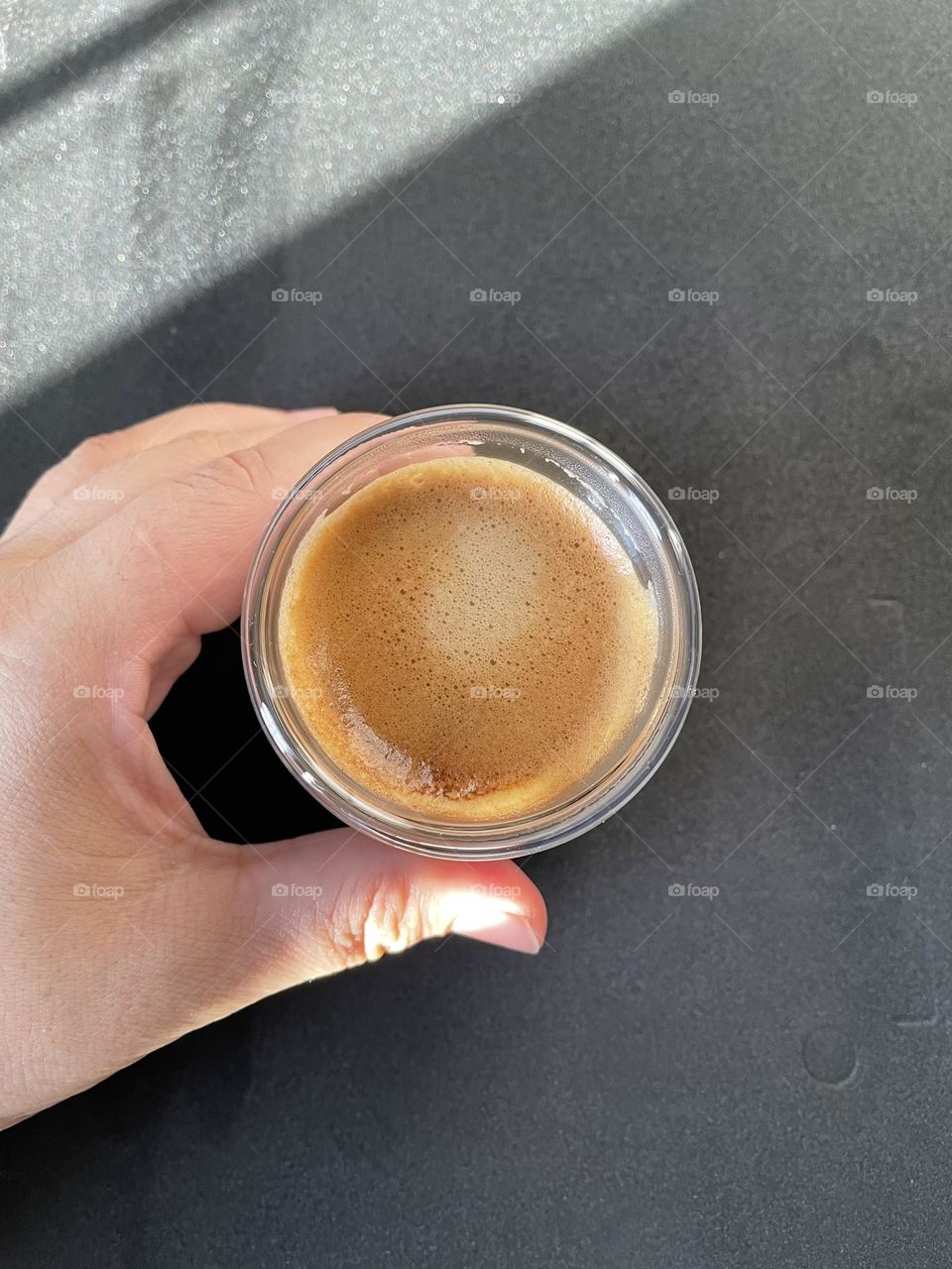 A hand holding a cup of coffee .