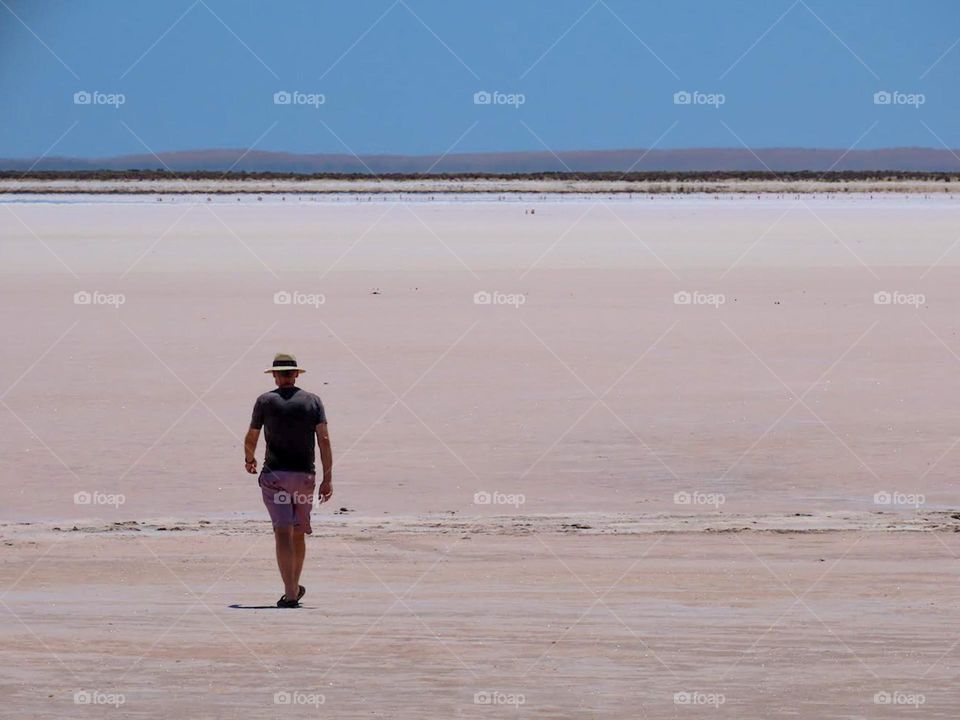 Man walking across a salt lake