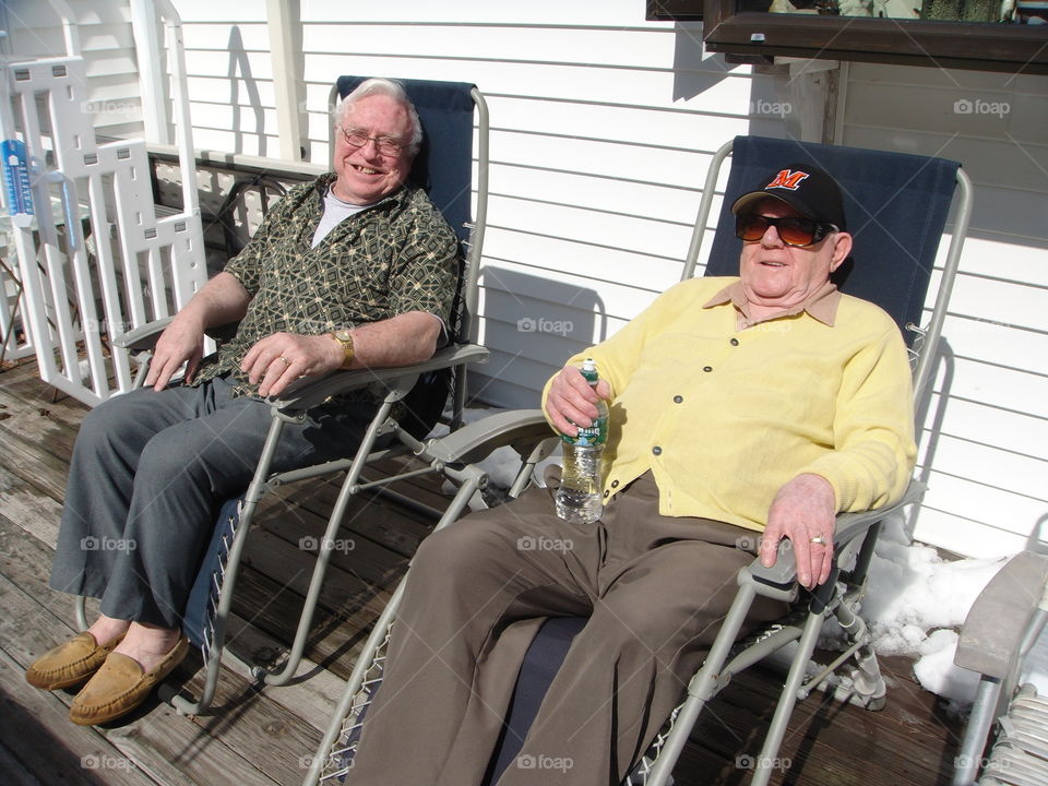 Grandfathers sitting in sun, back porch, having a good conversation. Good friends, love to visit.