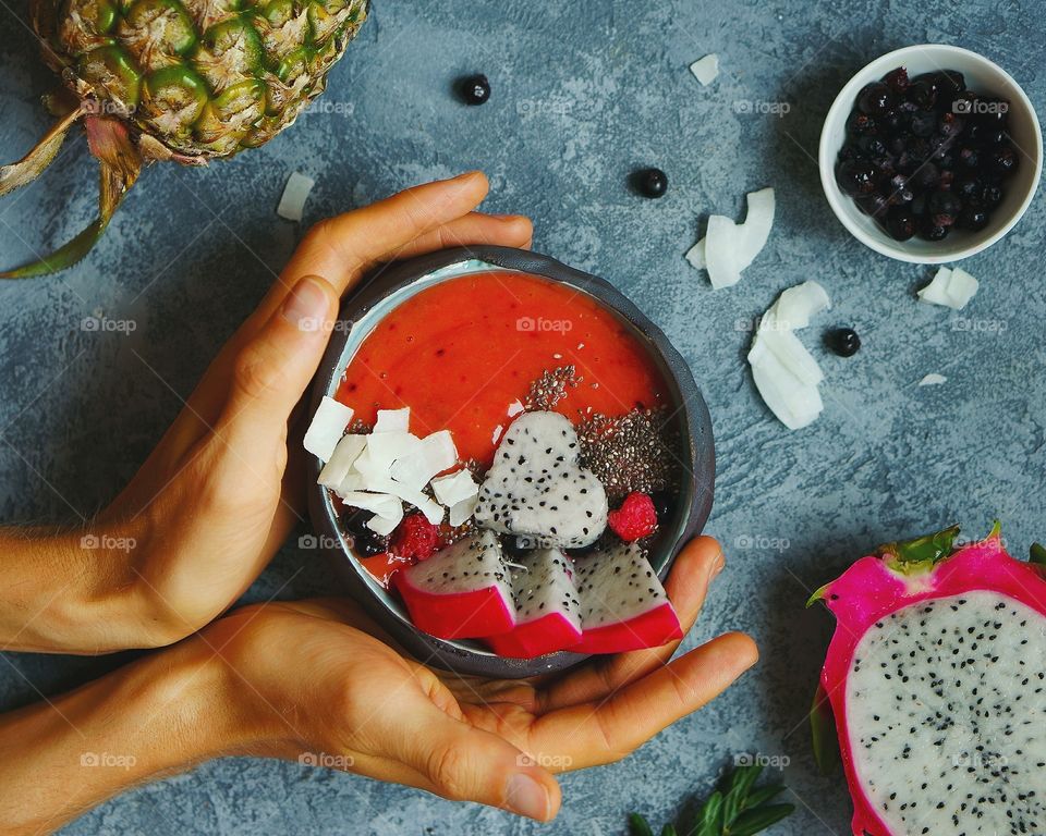 Person holding dragon fruit smoothie in hand